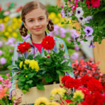 Summer flowers, girl holding flowers in garden center.