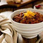 Chunky beef chili topped with cheddar cheese.